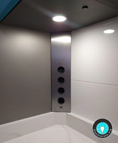 Regleta esquinera de acero inoxidable con cuatro enchufes instalada bajo un mueble alto de cocina